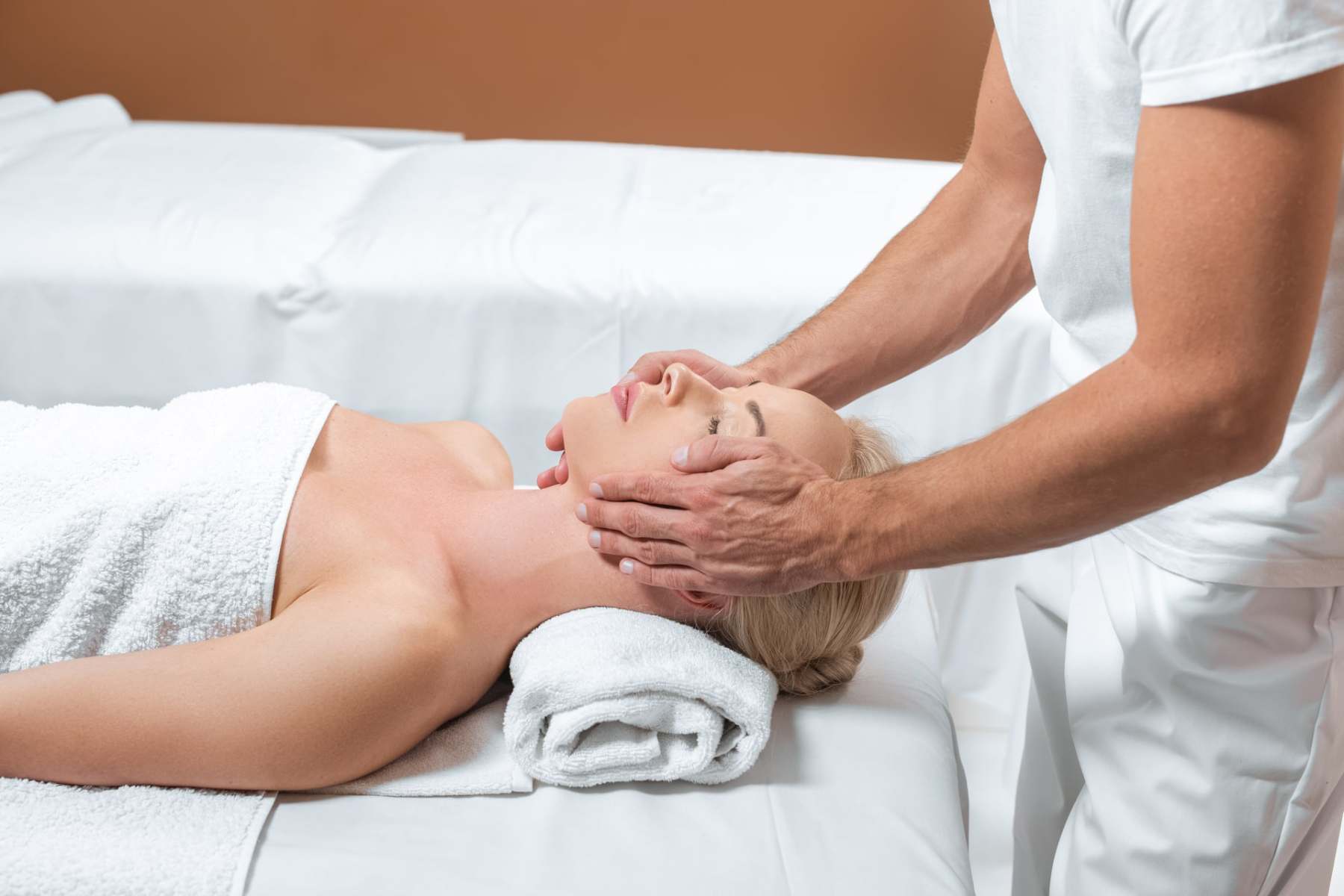 male-masseur-doing-face-massage-to-woman-in-spa-ro-2023-11-27-05-03-31-utc-min